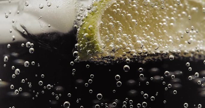 Lime ice and soda water bubbles turning close up