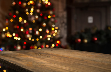 Wood table top on blur Christmas tree in snowfall background - can be used for display or montage your products