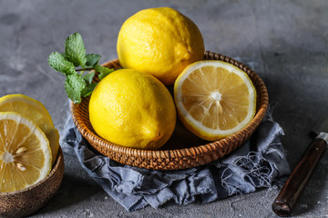 Photo of fresh ripe lemons on dark background. A slice of lemon with green leaves. Lemon fruit on...