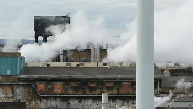 Low aerial view of a paper mill in the UK. Steam billowing from the Victorian infrastructure.