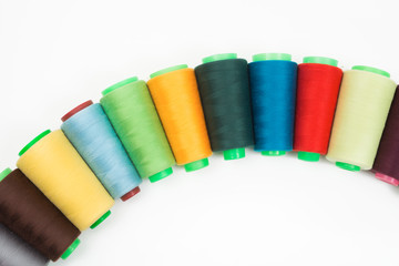 Colorful bobbin thread isolated on white background.
