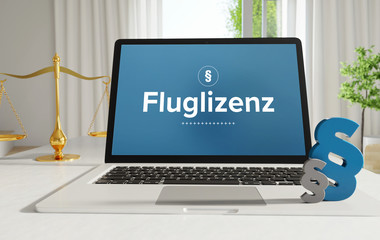 Fluglizenz – Recht, Gesetz, Internet. Laptop im Büro mit Begriff auf dem Monitor. Paragraf und Waage. .