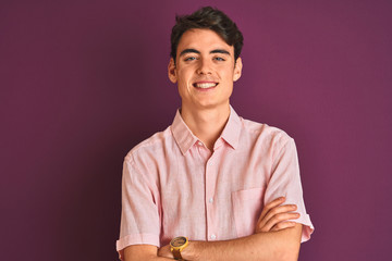 Teenager boy wearing pink shirt standing over purple isolated background happy face smiling with...