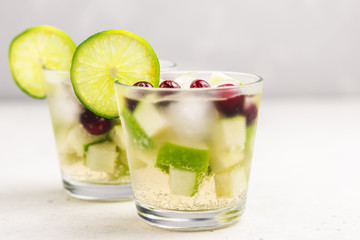 Green and red festive Christmas drink, apple cranberry white wine sangria. Selective focus, copy space.