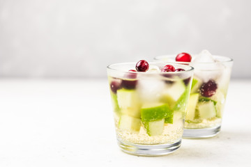Green and red festive Christmas drink, apple cranberry white wine sangria. Selective focus, copy space.