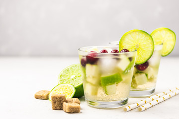 Christmas drink,citrus, apple cranberry sparkling cocktail on light background. Selective focus, copy space.