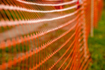 Plastic mesh enclosing a danger zone as a background. Close-up. Shallow depth of field