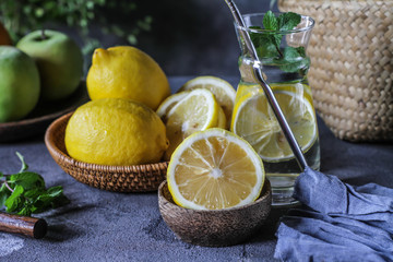 Photo of fresh lemon water on retro background. Lemon water with green leaves. Lemon fruit on...
