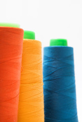 Colorful bobbin thread isolated on white background.