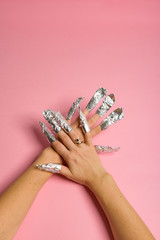 The procedure for removing varnish from nails hybrid nails in progress. Gel nail polish remover foils on woman's hands.