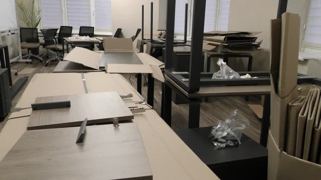 Disassembled furniture in the office. Assembly of new furniture. The mess of new furniture in the room.