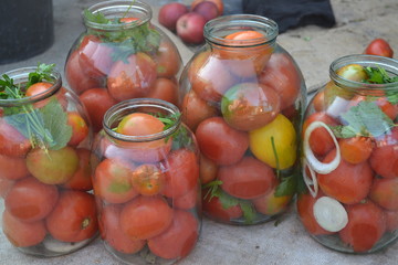 Fototapeta na wymiar Homemade food. Natural products from the garden. Village, cottage, farm, cellar. Tasty, healthy. Preservation. Blanks for the winter. Marinated. Red and yellow tomatoes in jars. Pepper. Spice