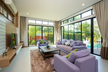 Naklejka na ściany i meble Spacious living room with pool view and purple couch