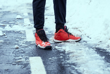 Sporty leg  in sneakers in the snow