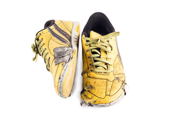 Old used  yellow worn out futsal sports shoes  on white background soccer sportware object isolated