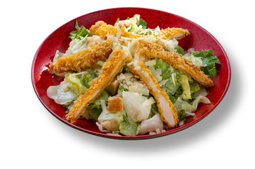 Fresh green salad with chicken in beautiful red modern plate