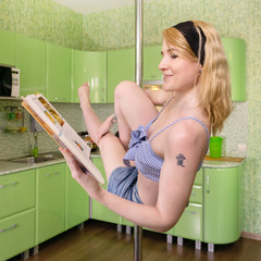 young woman reads cookbook while exercising in pole dance at home