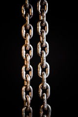 Obraz premium Rusty chains weathering. Chain on black background.