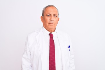 Senior grey-haired scientist man wearing coat standing over isolated white background with serious expression on face. Simple and natural looking at the camera.