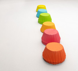 Wide shot of colorful cupcake wrappers lined up in a line