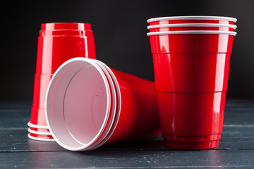 Wooden table with red cups and ball for beer pong - obrazy, fototapety, plakaty