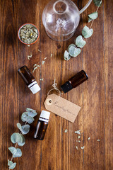 three bottles of eucalyptus essential oil with diffuser and dried herbs, top-view
