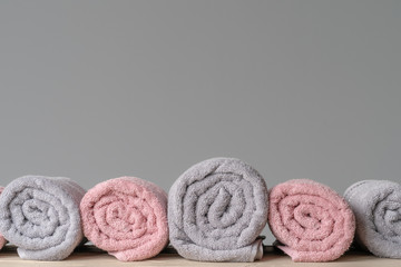 Obraz na płótnie Canvas Pile of clean new towels against grey wall