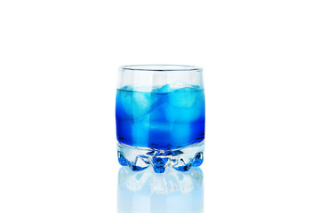 One glass of blue alcohol drink with ice cubes and reflection on white background isolated closeup, blue lagoon cocktail, absinthe shot, sambuсa, blue сuracao liquor, abstract neon color cold beverage