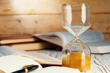 Hourglass with sand close up on wooden background