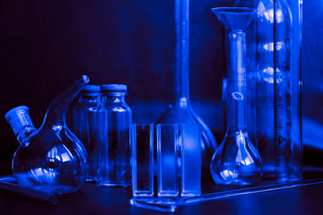 Set with different laboratory glassware and liquid for analysis on black background Glass chemistry...