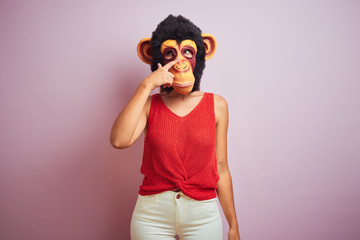 Woman standing wearing t-shirt and monkey mask