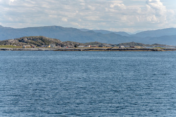 Fototapeta na wymiar houses on flat island shore, Skardsoya