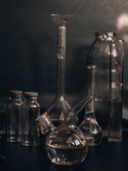 Set with different laboratory glassware and liquid for analysis on black background Glass chemistry...