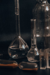Set with different laboratory glassware and liquid for analysis on black background Glass chemistry...