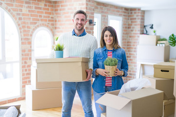 Young beautiful couple moving cardboard boxes at new home