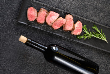 Bottle of wine with sliced filet mignon