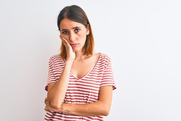 Fototapeta premium Beautiful redhead woman wearing casual striped red t-shirt over isolated background thinking looking tired and bored with depression problems with crossed arms.
