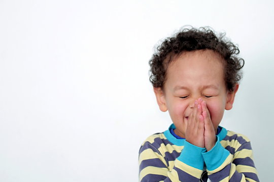 child praying to God stock image with hands held together with closed eyes