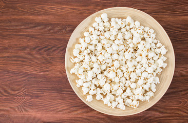 Pop corn snack in bowl, on the wooden table. Top view, banner mockup for cinema and tv movie