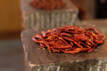 Close up heap of dry red peppers on stone. Blur background