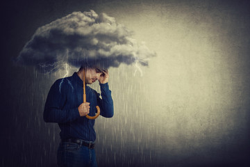 Pessimistic man, standing under rain, suffering anxiety as holding an umbrella thunderstorm cloud over head. Concept of memory loss and dementia disease. Alzheimer's losing brain and memory function. - obrazy, fototapety, plakaty