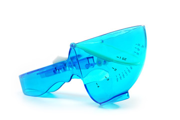 Close-up mechanical measuring spoon for bulk and liquid products on a white background