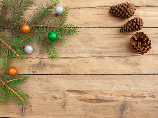 Christmas tree branches with Christmas balls on a wooden background