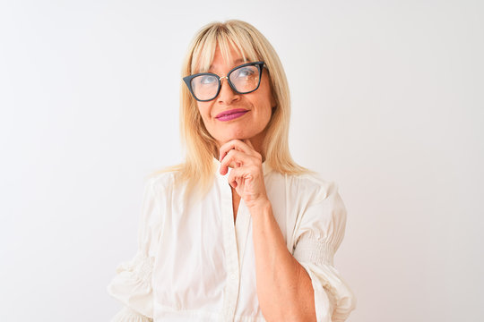Middle age businesswoman wearing shirt and glasses standing over isolated white background serious face thinking about question, very confused idea