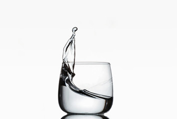 High splash of clear liquid in a glass goblet