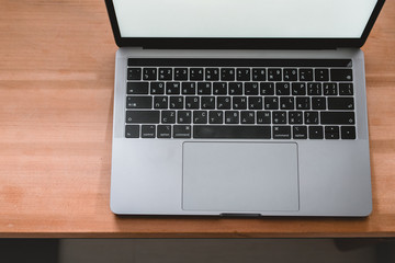 Conceptual workspace, Laptop computer with blank white screen on table, blurred background. use in Traditional Chinese Alphabet operating system.