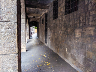 Fototapeta na wymiar Old and scary looking exterior hallway corridor next to an old building facade with dark and abandoned feeling to it.