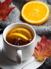 autumn and winter hot tea with cinnamon and orange . Warming drink and a warm knitted sweater