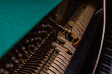 Close up of old broken dusty piano from the inside. Hammers in abandoned piano striking strings. Music playing from the ancient ruined piano. Gavel of the string open mechanism.