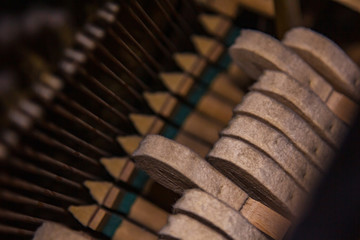 Close up of old broken dusty piano from the inside. Hammers in abandoned piano striking strings. Music playing from the ancient ruined piano. Gavel of the string open mechanism.